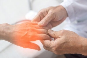 doctor holds neuropathy patient hand for social security examination