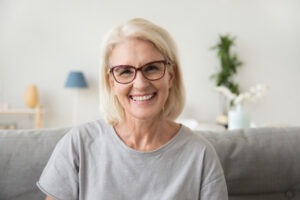 Smiling woman with white hair.