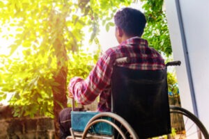 A disabled man in a wheelchair looking at trees.