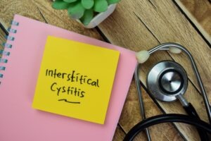 a stack of sticky notes with the words interstitial cystitis on top of a notebook next to a stethoscope