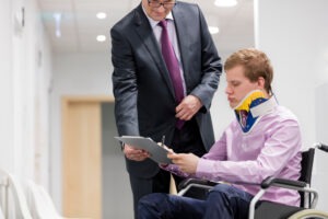 male patient with neck brace signing documents with a Social Security Disability lawyer