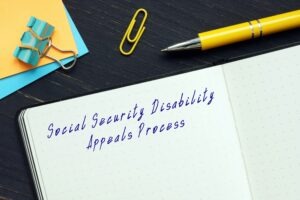 A notepad with “Social Security Disability Appeals Process” written at the top of a page, with someone nearby wondering about whether the Social Security Appeals Council is able to overturn an administrative law judge (ALJ) decision