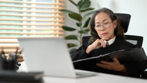 An administrative law judge, after a social security disability hearing, is looking at the documents from the case