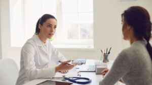 Doctor meeting with a patient, and the patient is unsure about whether they can get SSDI after 55 if they miss too many workdays for medical care